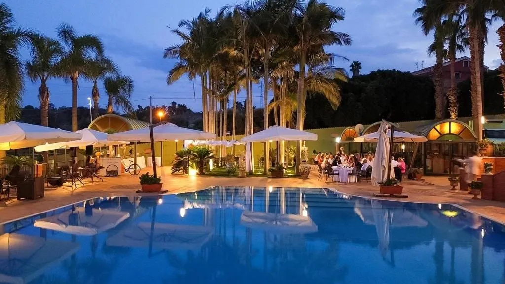 La piscina por la noche con las sombrillas