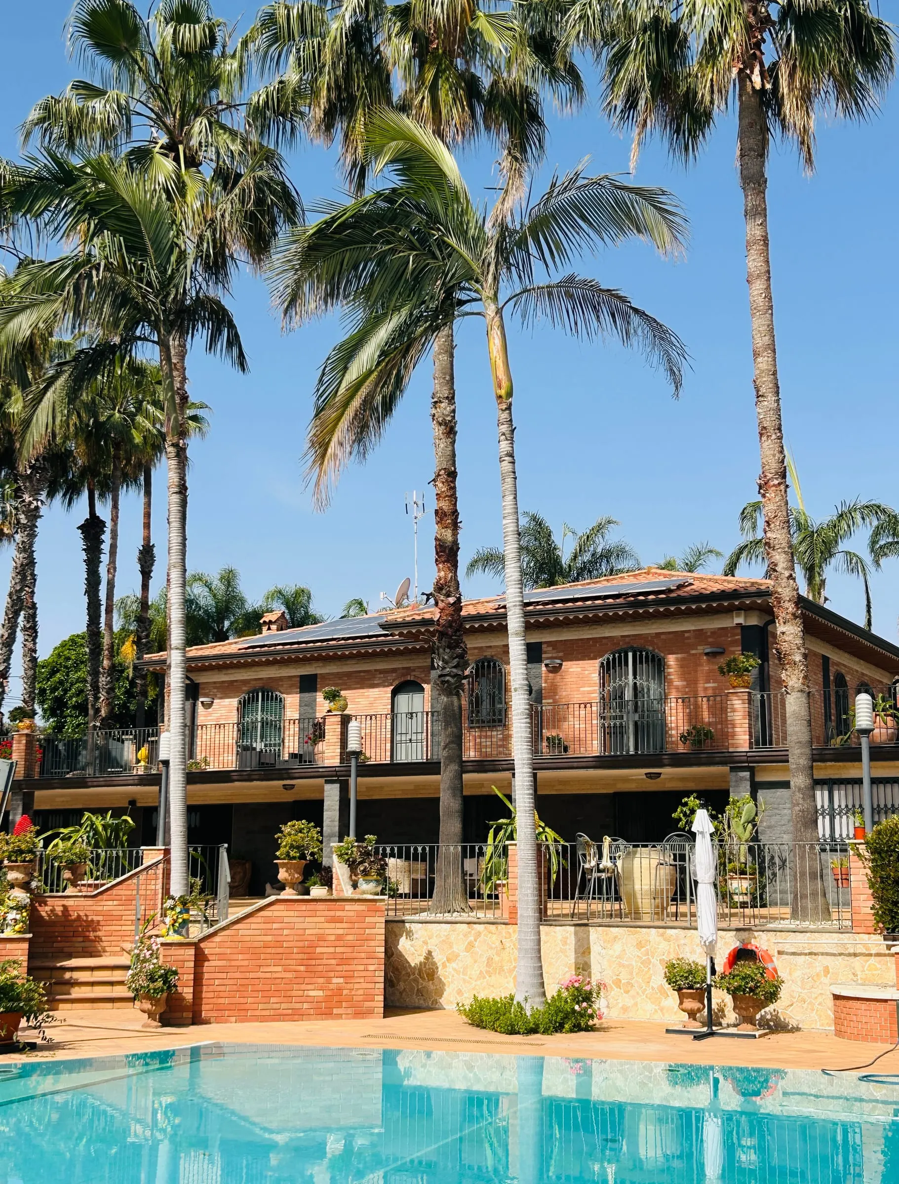 La villa vista dalla piscina tra le palme
